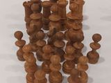 a pile of wooden chess pieces on a white surface