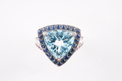 un gros plan d'une bague sertie d'une topaze bleue et d'un saphir bleu