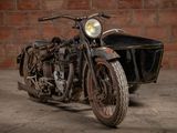 a motorcycle with a side car parked in front of a brick wall