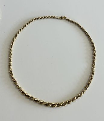 a close up of a gold bracelet on a white surface