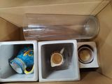 two cups of coffee in a box with a cup of coffee in it