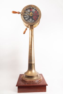 an old fashioned brass clock on a wooden stand on a white background