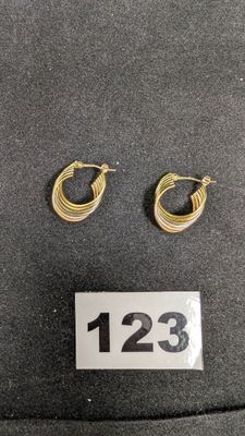 deux paires de boucles d'oreilles en anneau dorées sur un chapeau noir