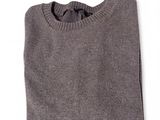 un gros plan d'un pull gris sur fond blanc