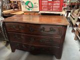 une commode dans un magasin, sur laquelle est posée une boîte