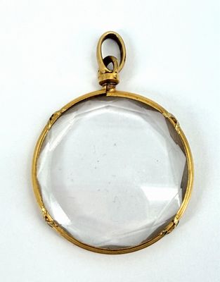 un pendentif plaqué or renfermant un verre transparent