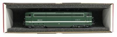 un train vert dans une boîte posée sur une surface blanche