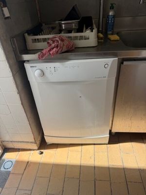 a white dishwasher sitting in the corner of a kitchen