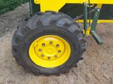 a yellow tractor with a big tire on the ground