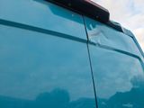 a close up of a blue van with a hole in the side