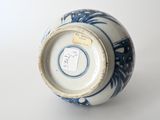 a blue and white vase sitting on a white surface