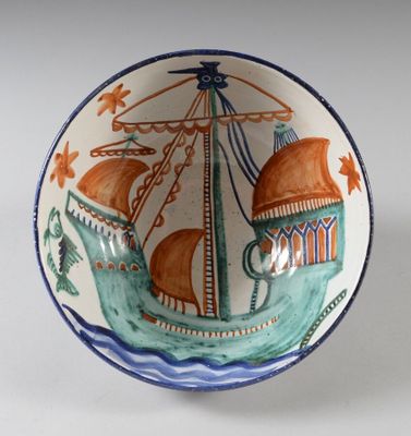 un petit bol orné d'un bateau, posé sur une table