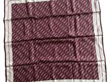 a close up of a red and white square scarf on a white background