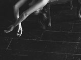 black and white photograph of a naked woman laying on a chair