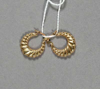 deux paires de boucles d'oreilles créoles en or suspendues à un fil blanc