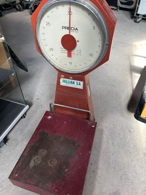 une balance rouge et blanche posée sur le sol d'une pièce