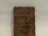 une image représentant un morceau de bois sculpté posé sur une surface blanche