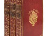 un lot de trois livres rouges ornés de motifs dorés