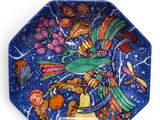 a blue plate with a colorful bird design on it
