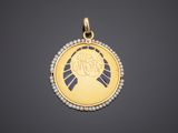 a gold and pearl pendant with a woman ' s face