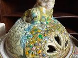 a ceramic sculpture of a cat sitting on top of a plate