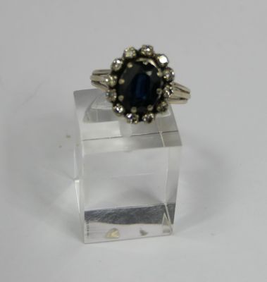a close up of a ring on a clear stand on a white surface