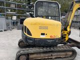 a small yellow excavator parked in a parking lot
