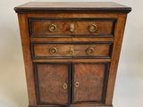 une petite commode en bois à deux portes et deux tiroirs