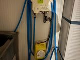 un tuyau bleu fixé au mur à côté d'un évier