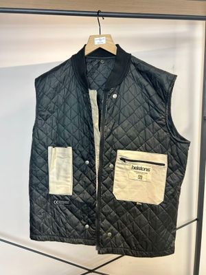 un gilet matelassé noir suspendu à un portant dans un magasin de vêtements
