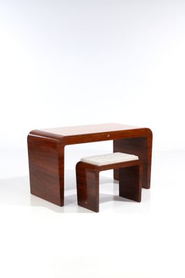 une petite table en bois avec deux tabourets devant