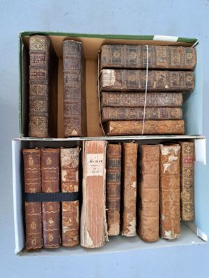 de nombreux livres anciens dans une boîte posée sur une étagère