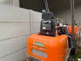 une petite machine orange garée devant un immeuble