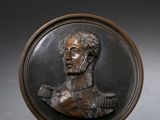 plaque en bronze représentant le buste d'un homme, posée sur un socle