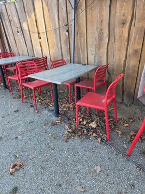 de nombreuses chaises et tables rouges devant une clôture en bois