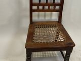 a wooden chair that has a woven seat on it