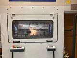 une machine qui se trouve dans une pièce où il y a une affiche accrochée au mur