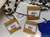 three tags on a table with a bag of clothes and a pair of gloves