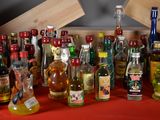 many bottles of alcohol on a red table cloth