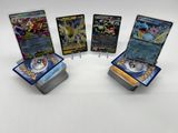 quatre cartes Pokémon différentes posées les unes sur les autres sur une table