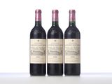 three bottles of red wine are lined up on a table