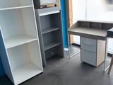 une photo d'une pièce avec un bureau et des étagères
