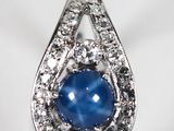 un gros plan sur une bague sertie d'un saphir étoilé bleu et de diamants