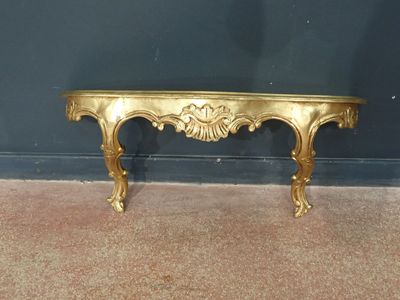 a gold table with a gold top on a carpeted floor