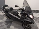 un scooter garé sur un sol en damier