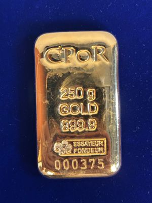 un gros plan d'un lingot d'or sur un fond bleu