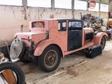 an old pink car in a garage with a lot of junk