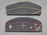 two military hats with gold stars on them sitting on a table
