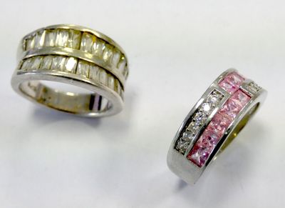 two rings with pink and white diamonds on a white surface