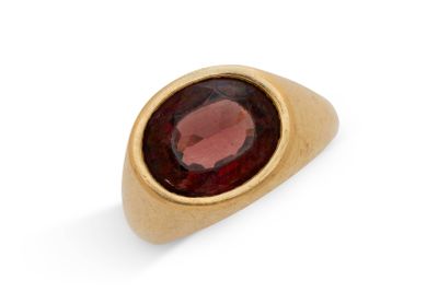gros plan d'une bague en or avec une pierre rouge